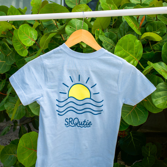 Back view of the Youth Sunset SRQutie Tee in Light Blue