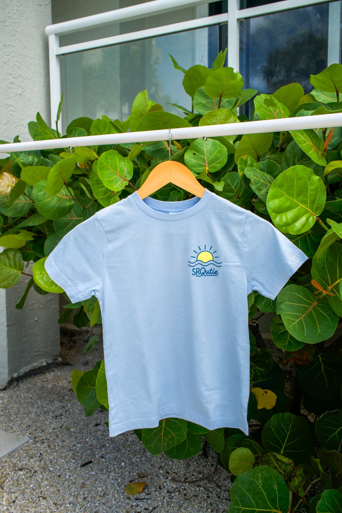 Front view of the Youth Sunset SRQutie Tee in Light Blue