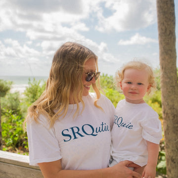 Mom and toddler in matching white Signature SRQutie tees on Siesta Key