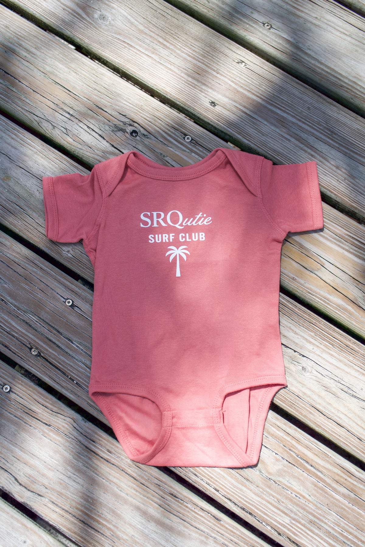 The Baby Surf Club SRQutie Onesie in Mauve