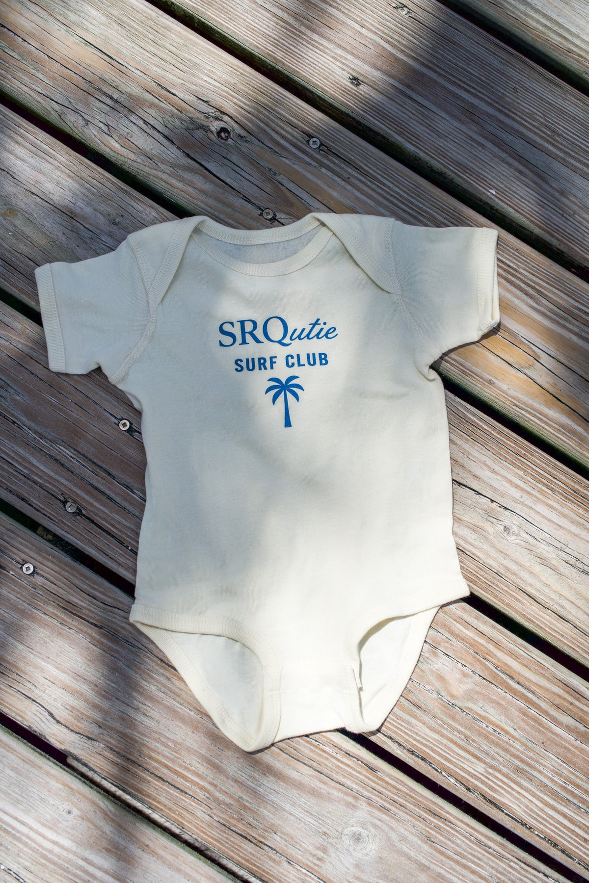 The Baby Surf Club SRQutie Onesie in Natural