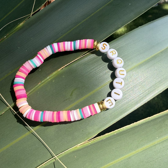 SRQutie pink clay bead bracelet on a palm leaf