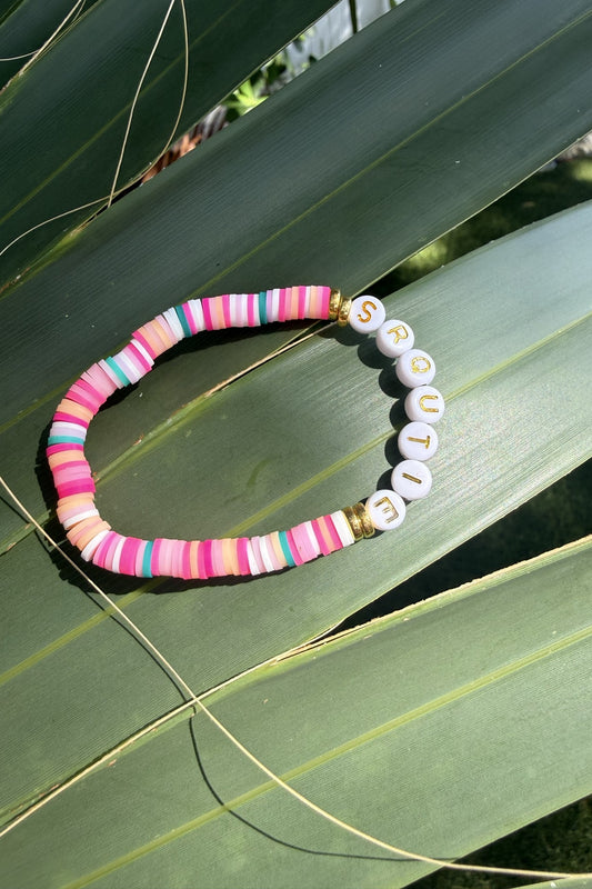 SRQutie pink clay bead bracelet on a palm leaf